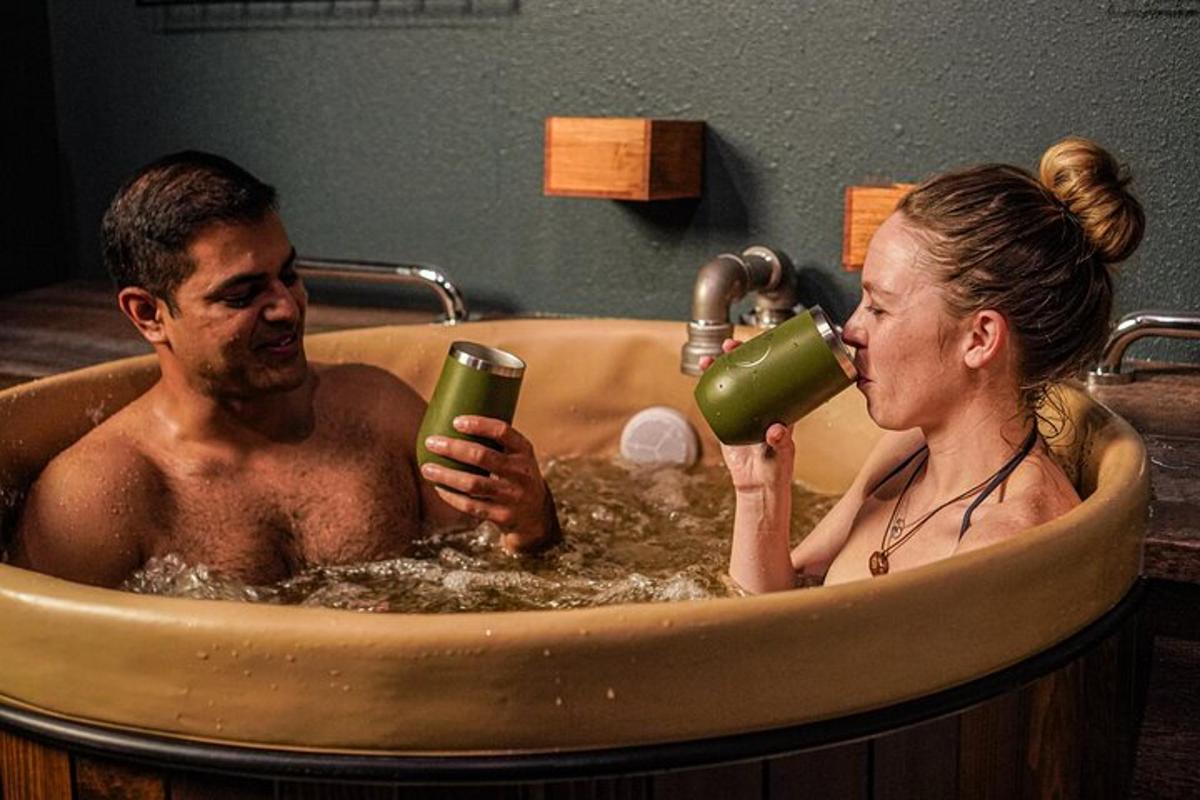 a man and a woman in a tub drinking