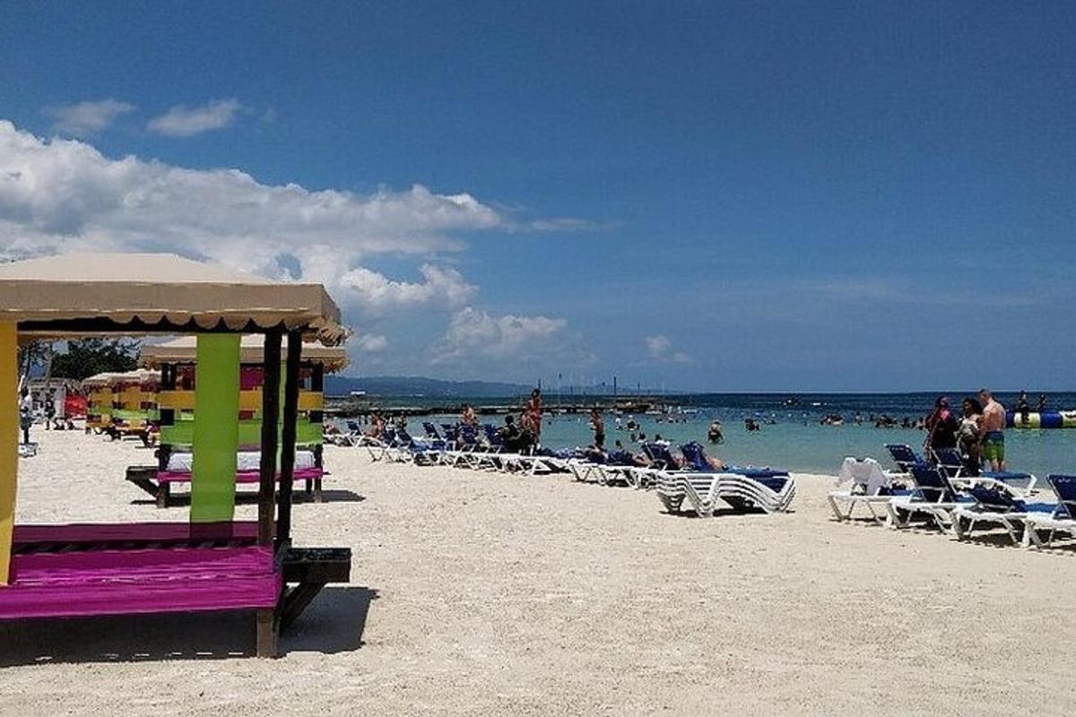 μια παραλία με καρέκλες και ανθρώπους στο νερό