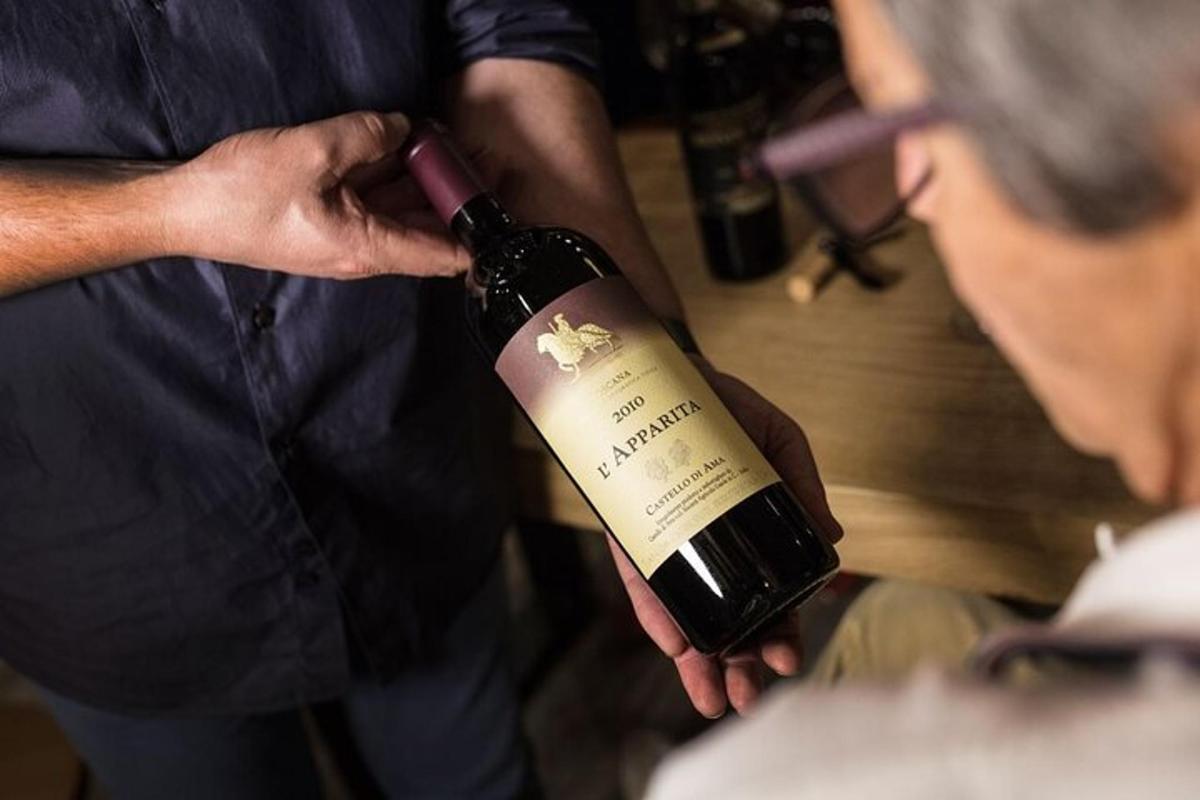 a man is holding a bottle of wine