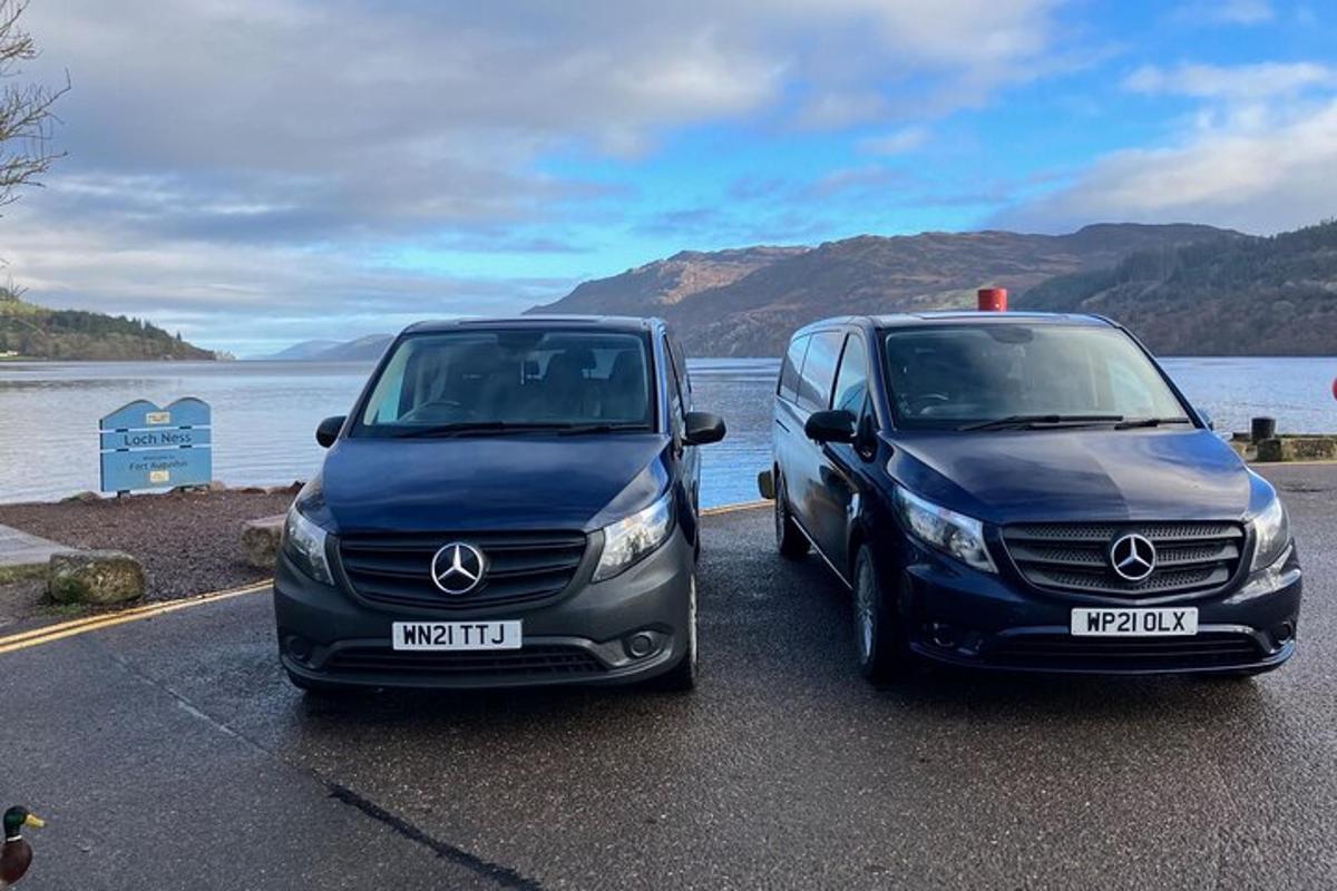 Dos coches estacionados junto a un cuerpo de agua