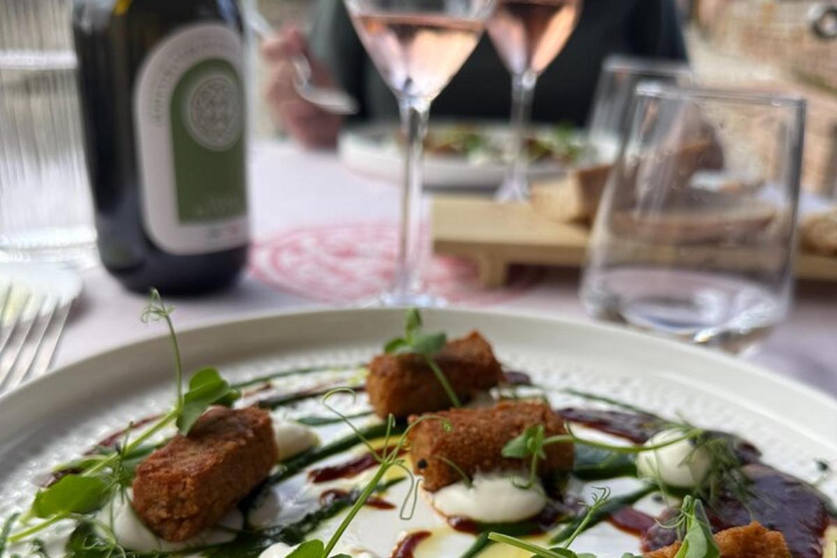 a plate of food on a table with a glass of wine