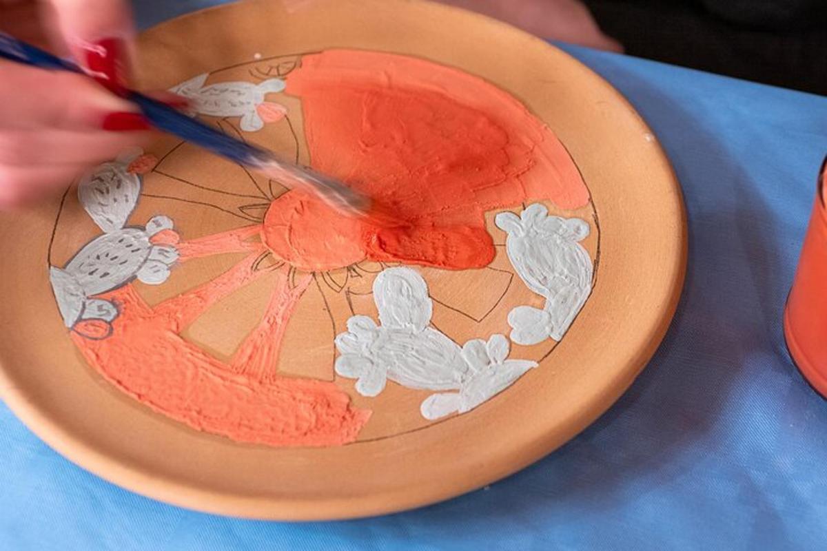a person cutting a plate with a painting of an umbrella