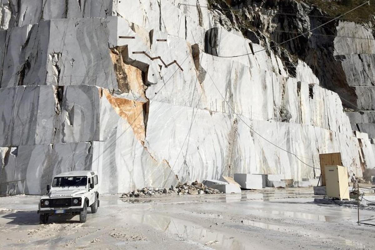Un camión blanco estacionado junto a una pared de roca