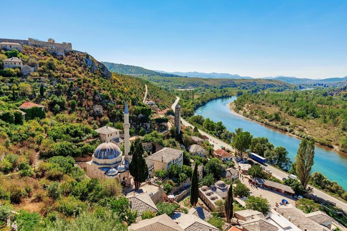 an aerial view of a village next to a river
