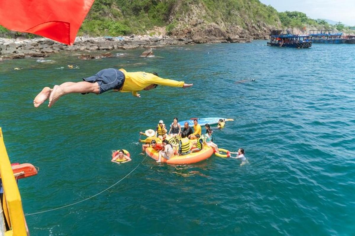 a group of people jumping off a raft in the water