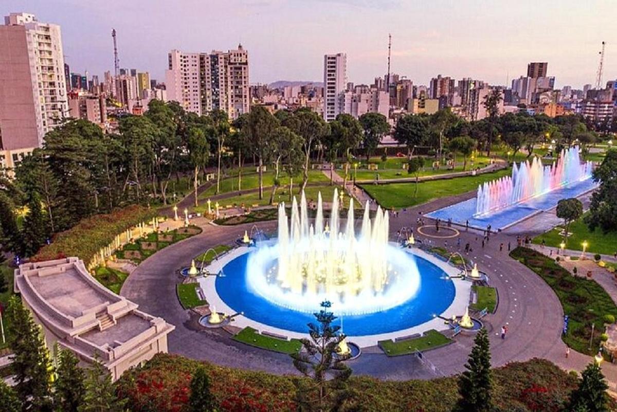 air mancur di taman dengan kota di latar belakang
