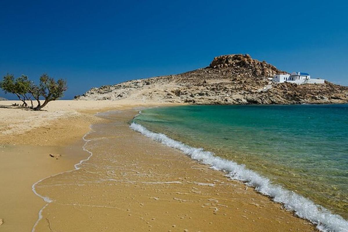 uma praia com uma casa no topo de uma colina