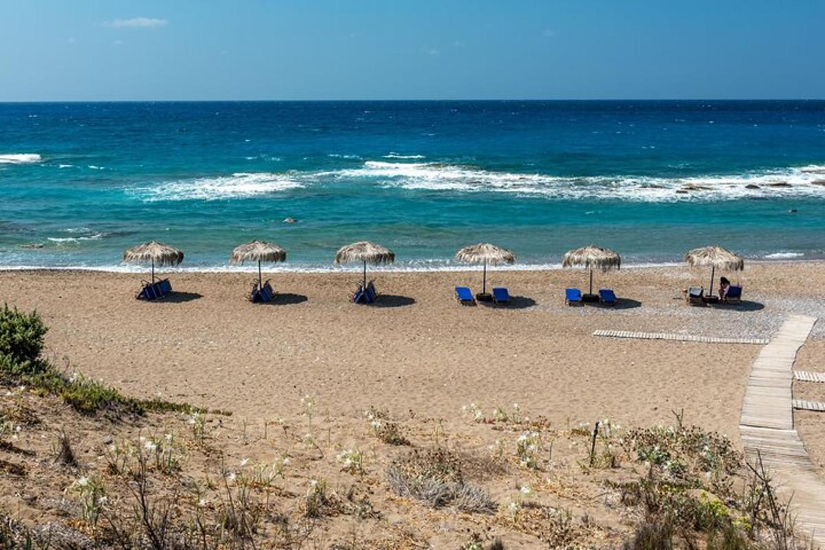 een strand met stoelen en parasols en de oceaan