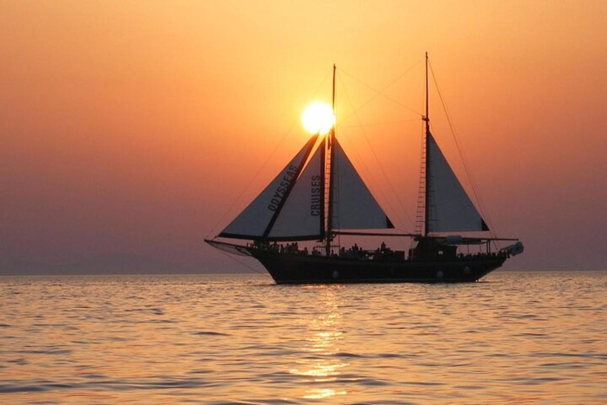 un veler a l'oceà a la posta de sol