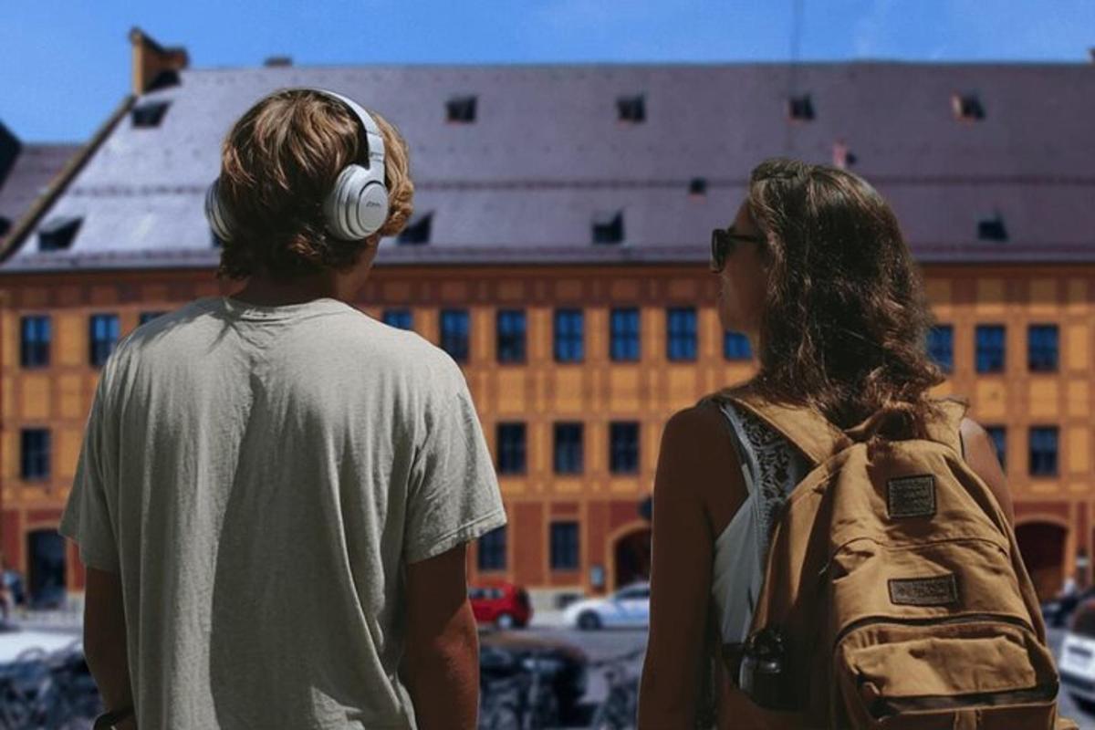 a man and woman wearing headphones looking at a building