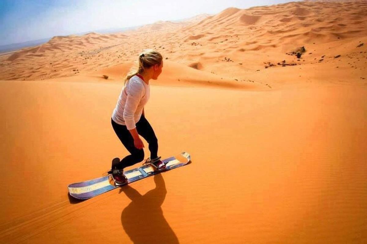 eine Frau, die mit einem Skateboard durch die Wüste läuft