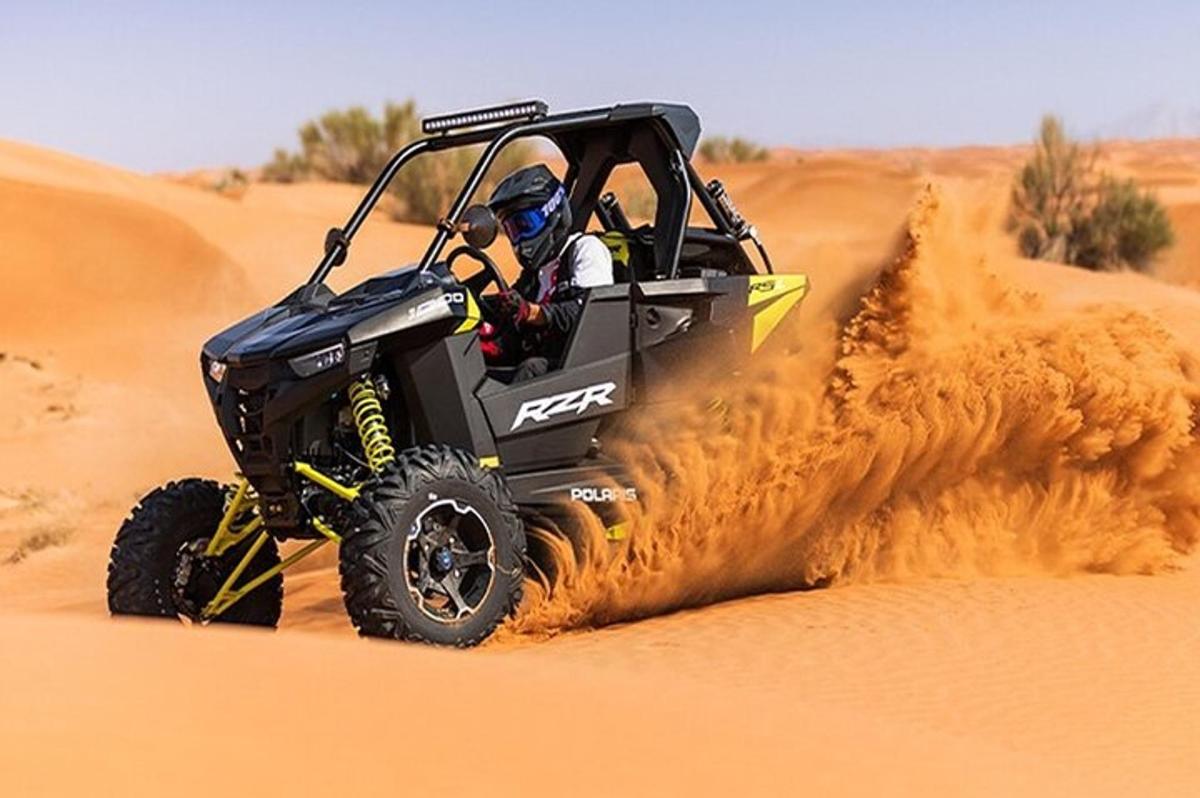 eine Person in einem Jeep, der durch die Wüste fährt