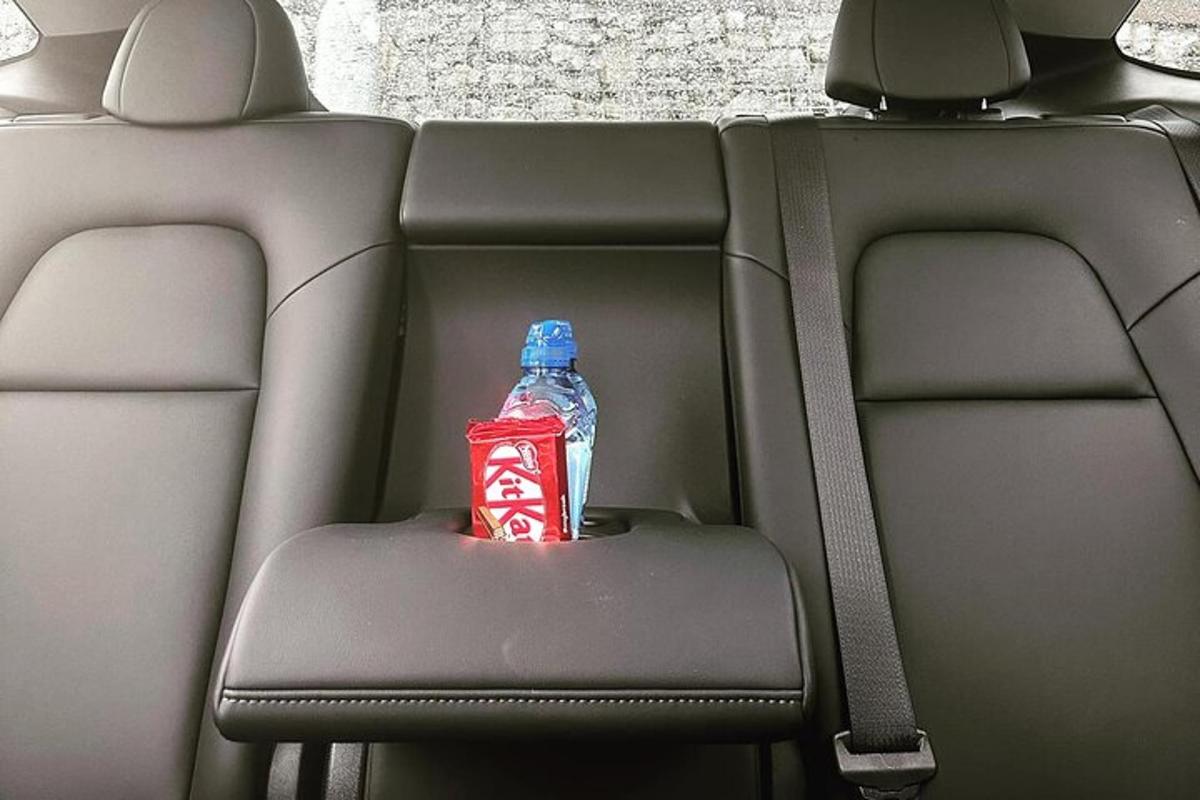 una bottiglia di soda appoggiata sul sedile posteriore di un'auto