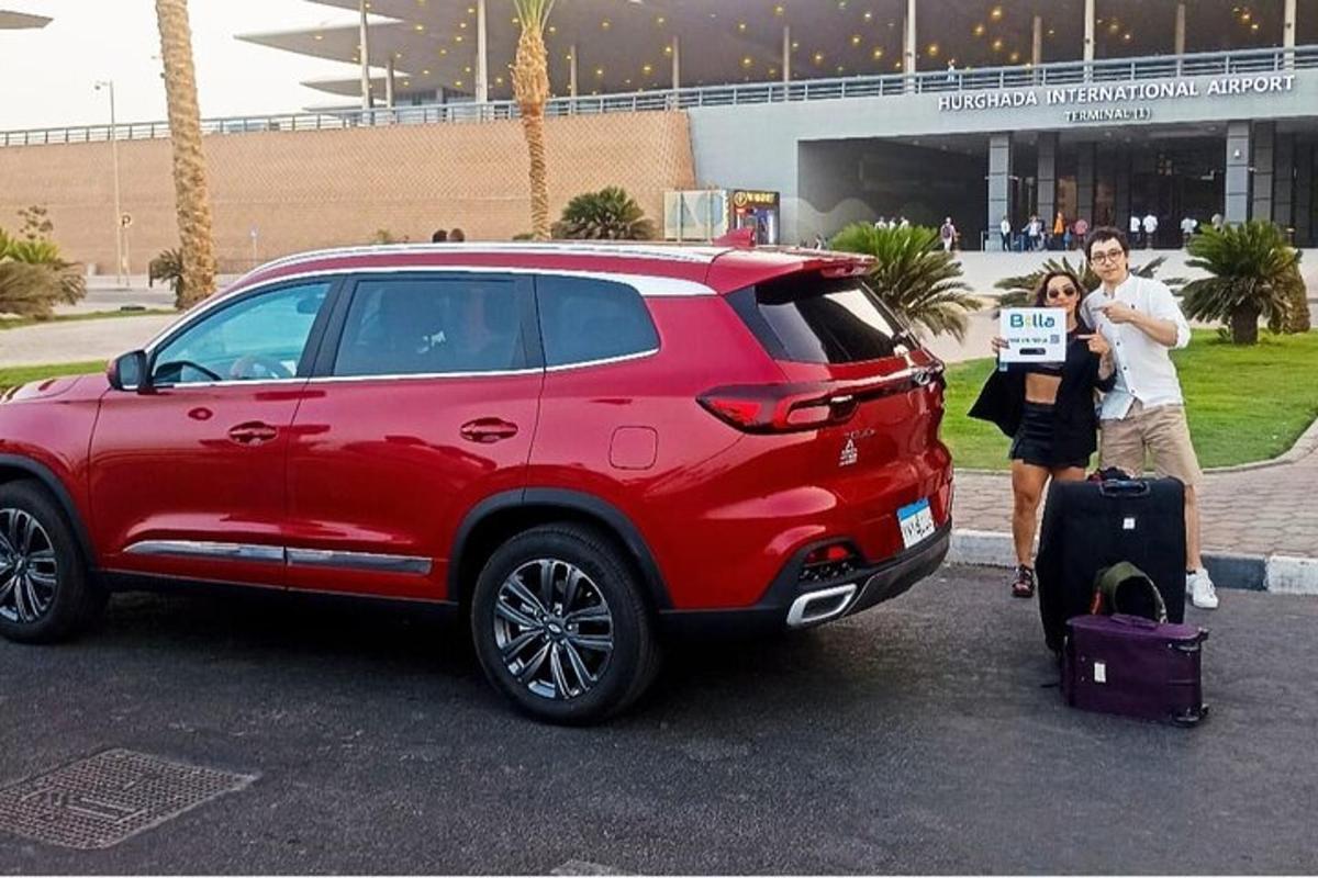 um grupo de pessoas em pé ao lado de um SUV vermelho