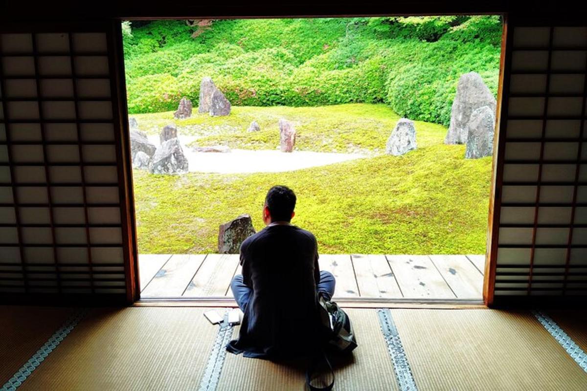 a man sitting in front of a door looking at a view