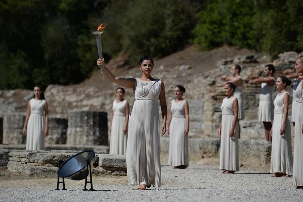 μια γυναίκα στα λευκά που κρατάει ψηλά έναν φακό