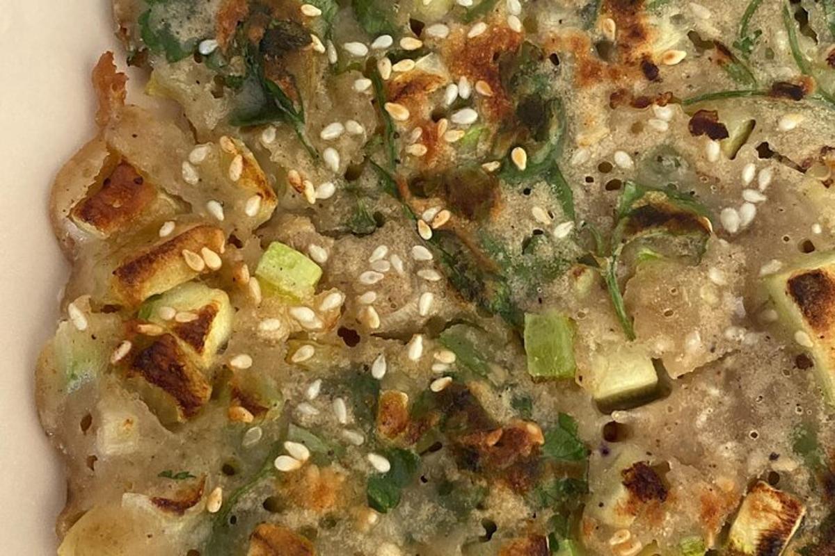 pizza se sezamovými semínky a zeleninou na talíři