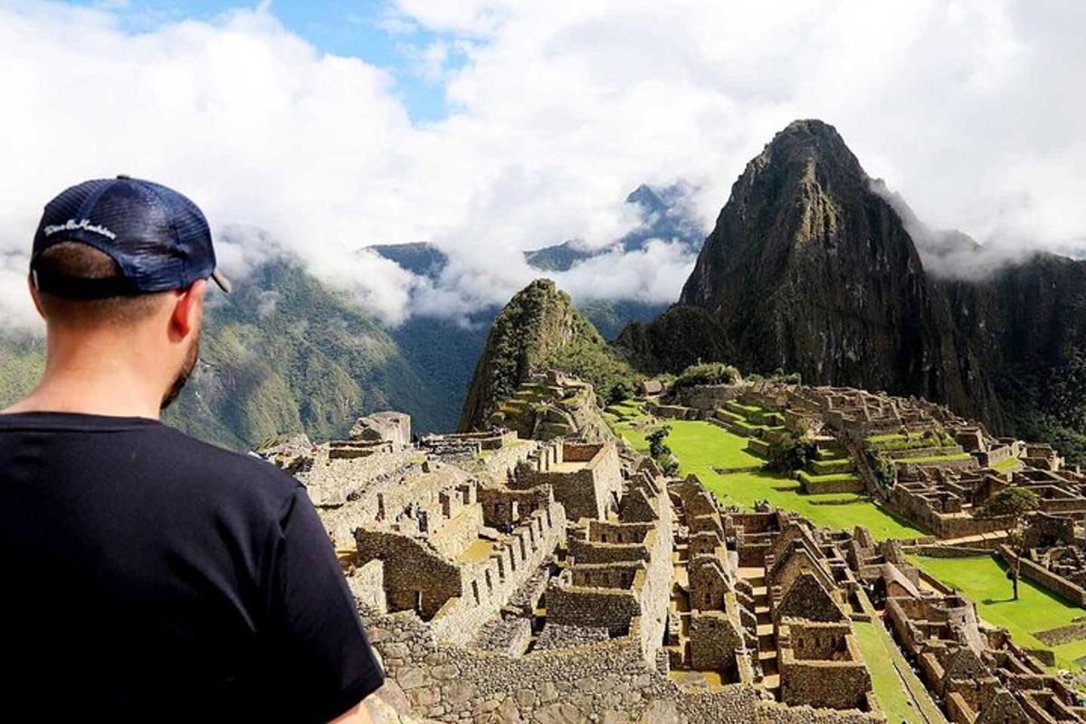 un uomo in piedi su una montagna che guarda delle rovine