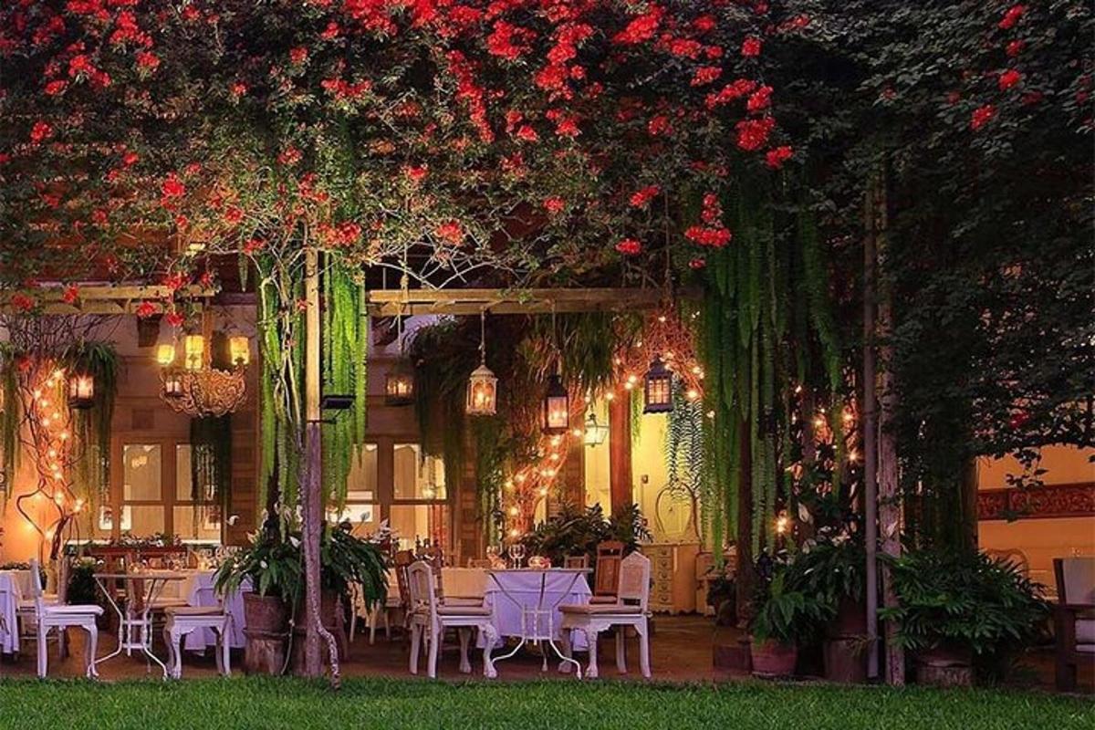 một nhà hàng có bàn ghế và hoa đỏ