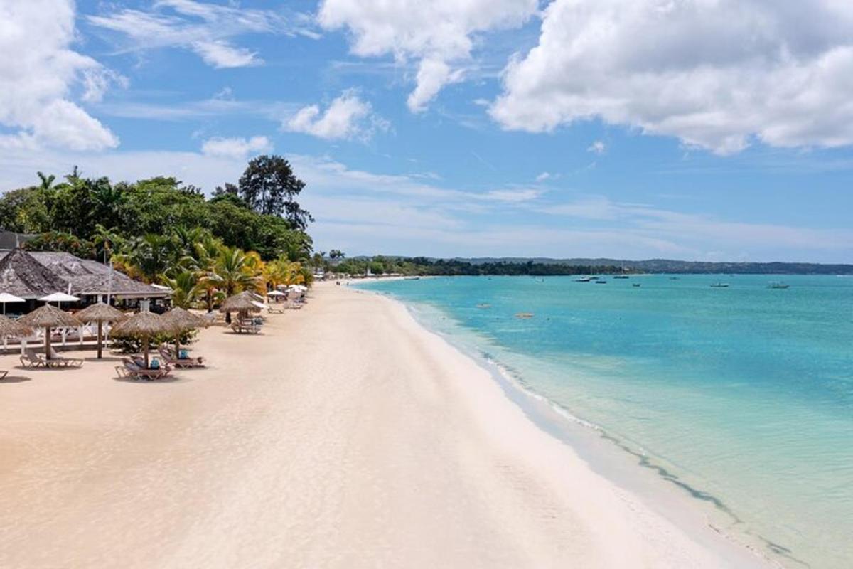 plaža z ležalniki in senčniki ter ocean