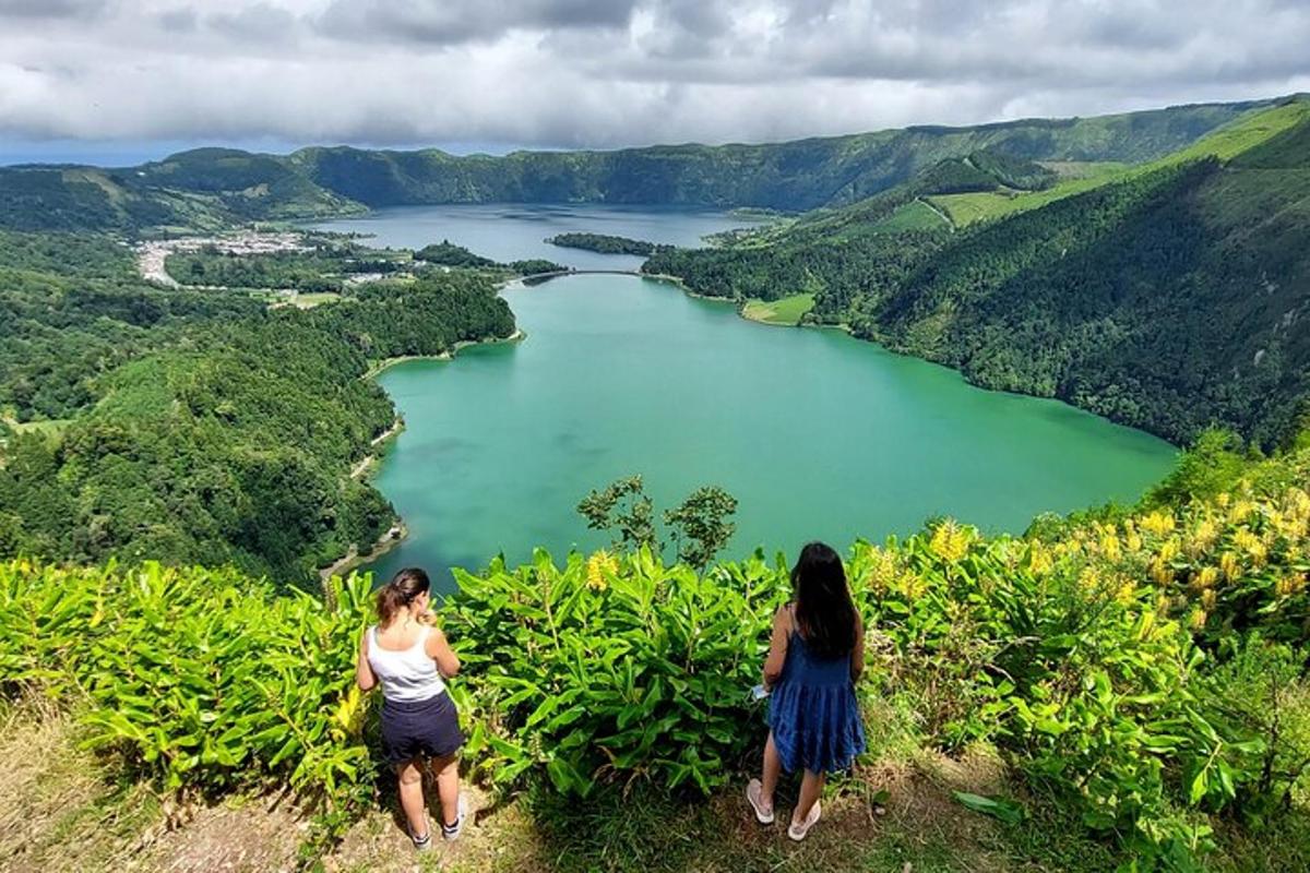dua wanita berdiri di atas bukit sambil memandangi danau