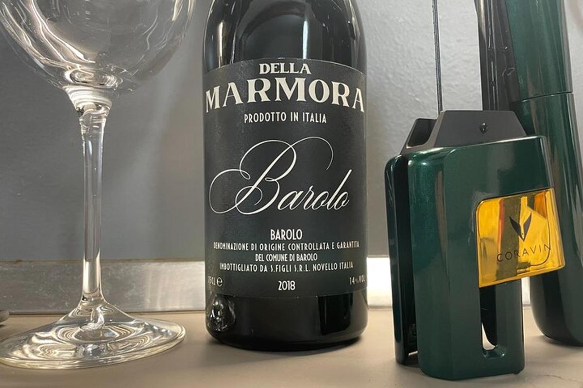o sticlă de vin așezată lângă un pahar de vin
