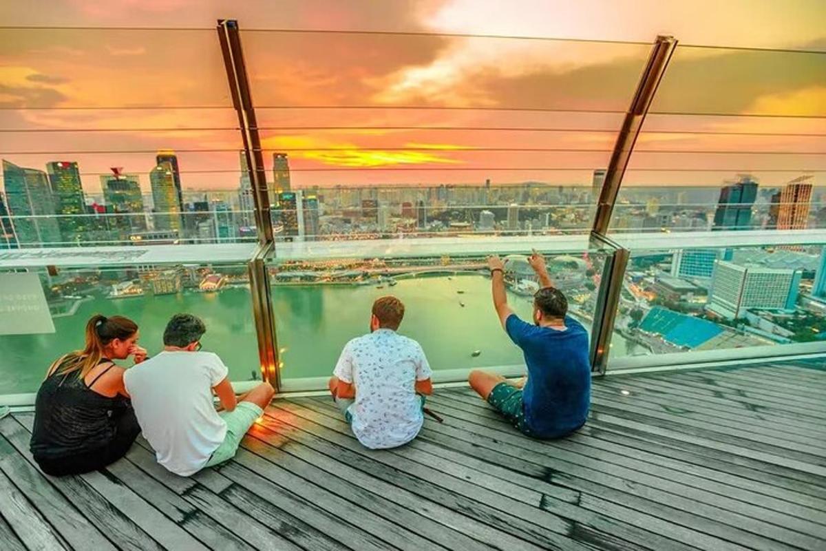 a group of people sitting on a observation deck watching the sunset