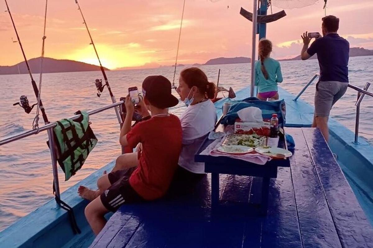 skupina lidí sedících kolem stolu na lodi