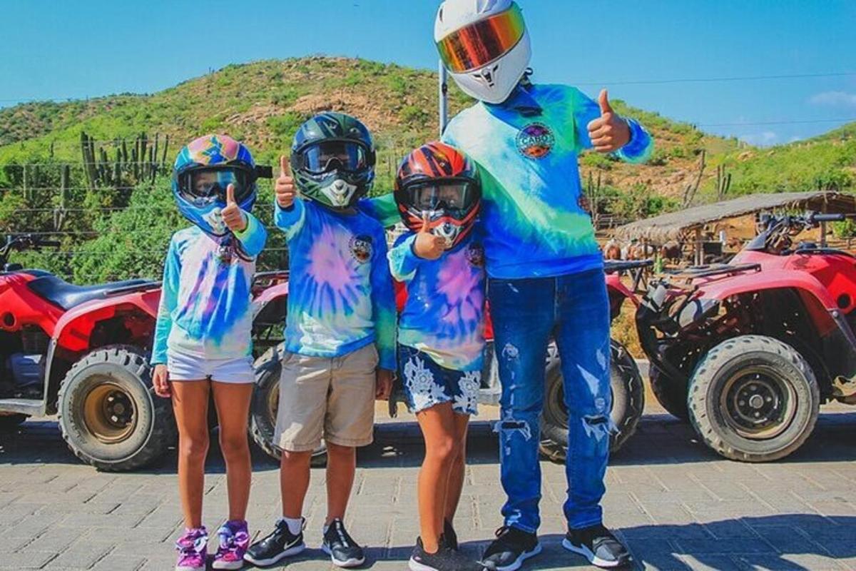 ヘルメットをかぶって親指を立てている男性と2人の子供