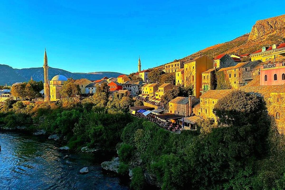 a group of buildings on a hill next to a river