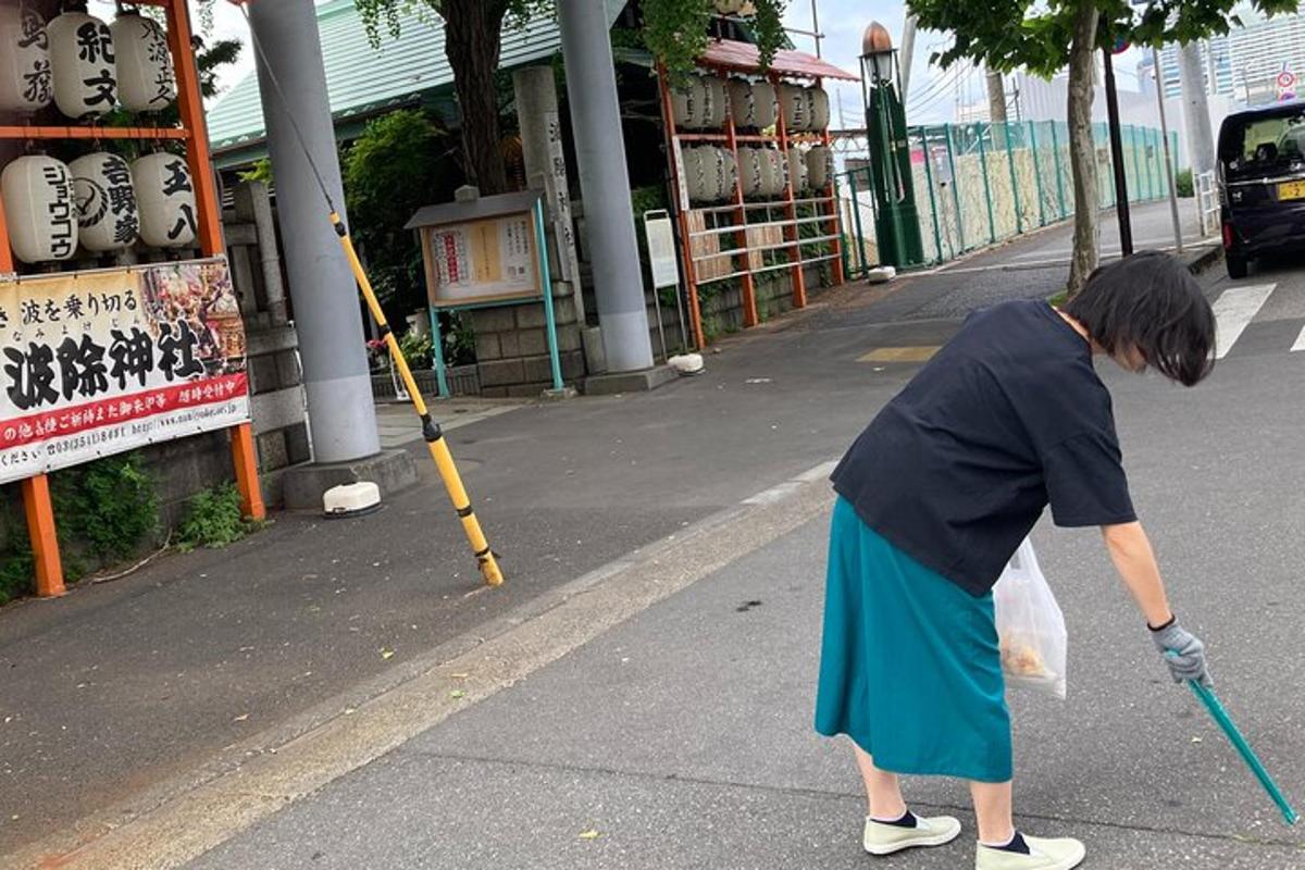 a woman walking down a street with a broom