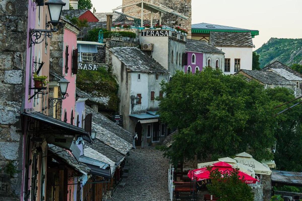 μια ομάδα κτιρίων με τραπέζια και ομπρέλες σε έναν δρόμο