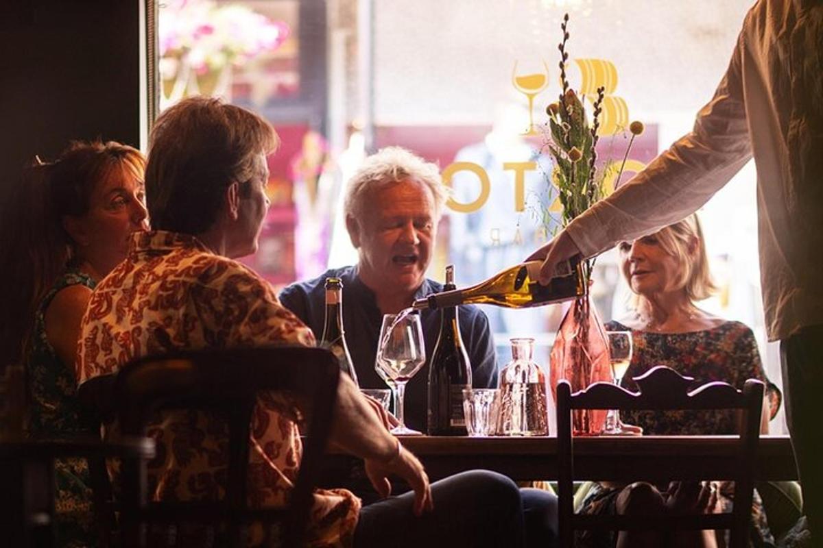 a group of people sitting at a table drinking wine