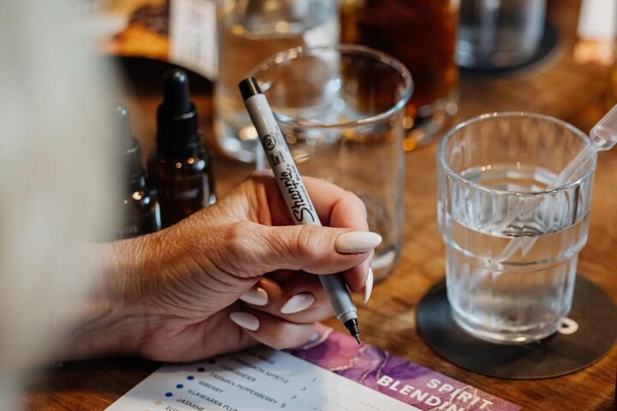 una persona che tiene una penna su un tavolo con un bicchiere