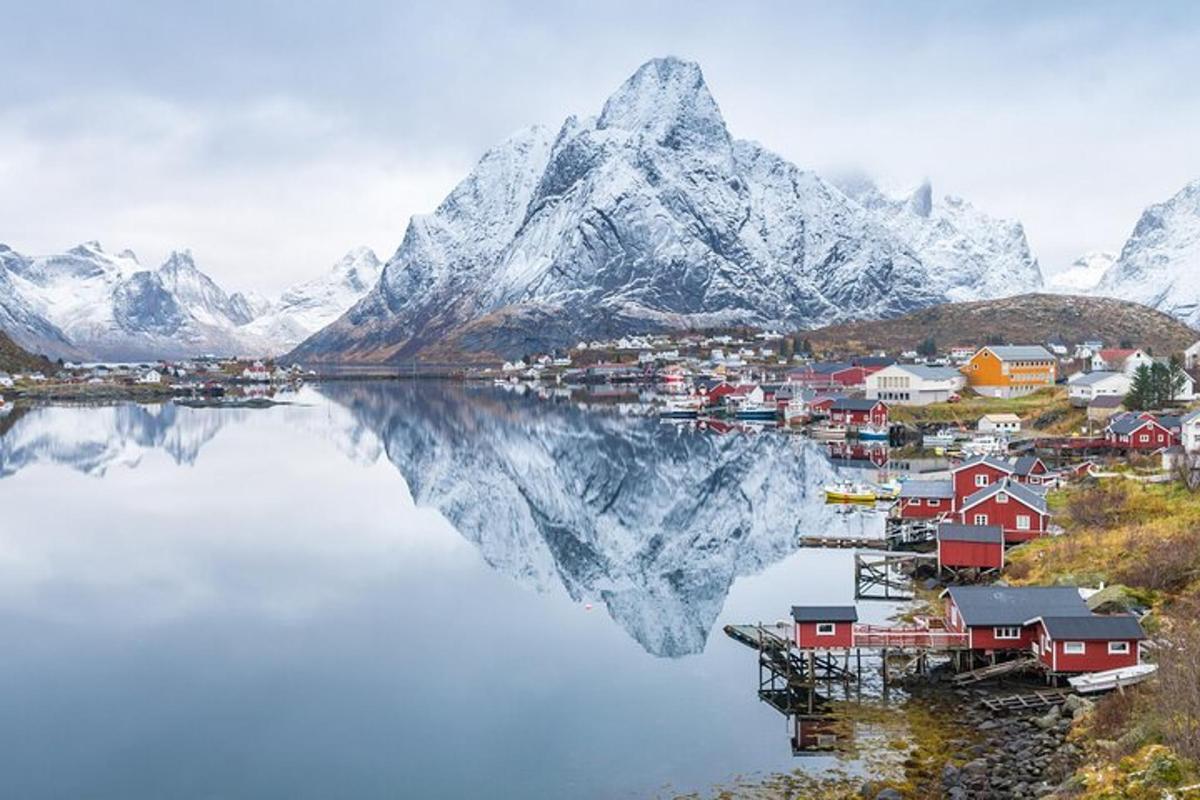 a village on a body of water with a mountain
