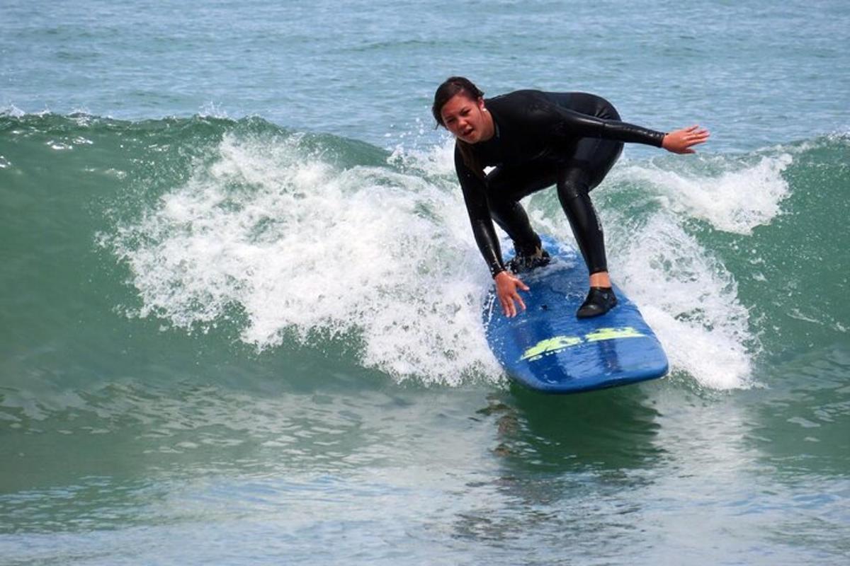 mężczyzna jadący na desce surfingowej na fali w oceanie