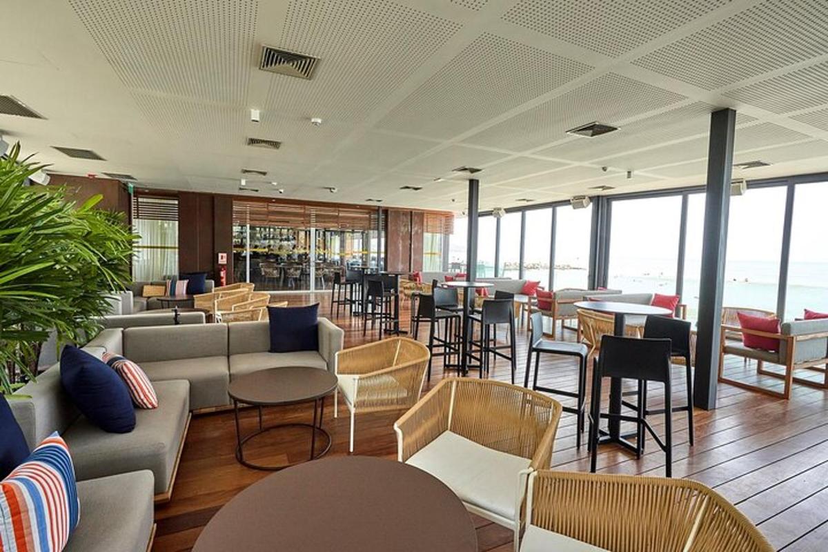 Un restaurante con sofás, sillas, mesas y ventanas.