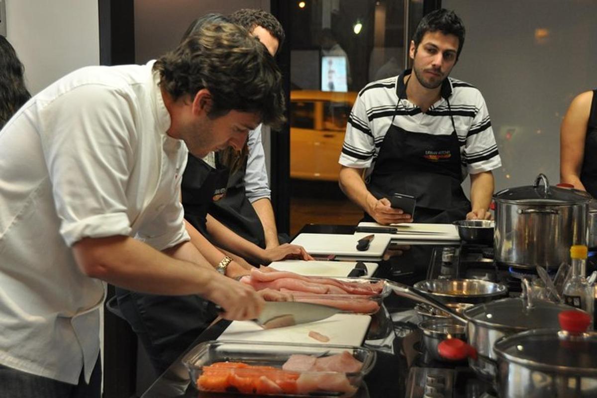 un grup d'homes dempeus a la cuina preparant menjar