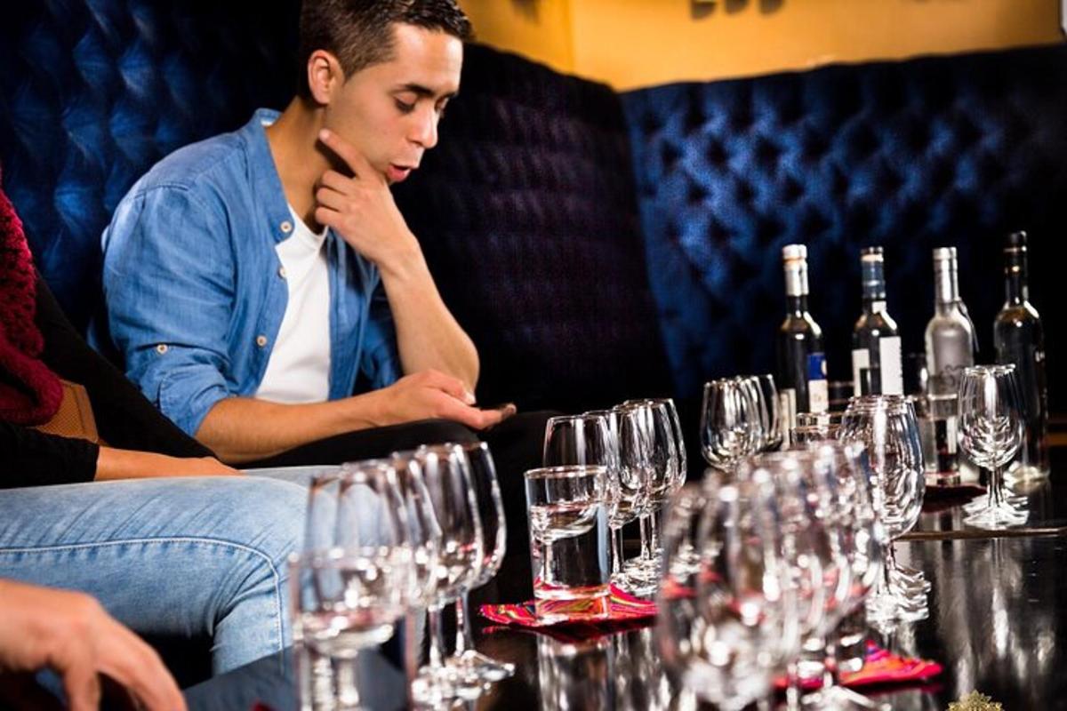 um homem sentado à mesa com taças de vinho