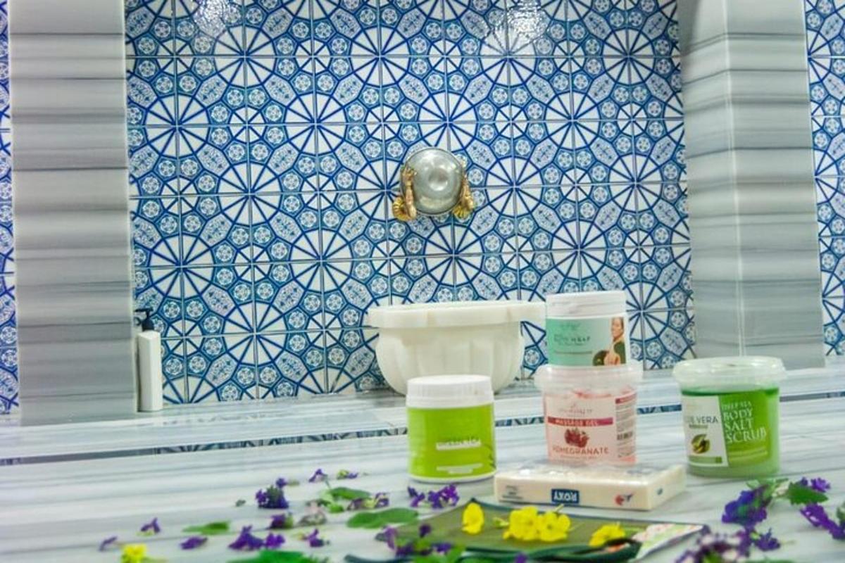Un baño con lavabo y azulejos azules y blancos.