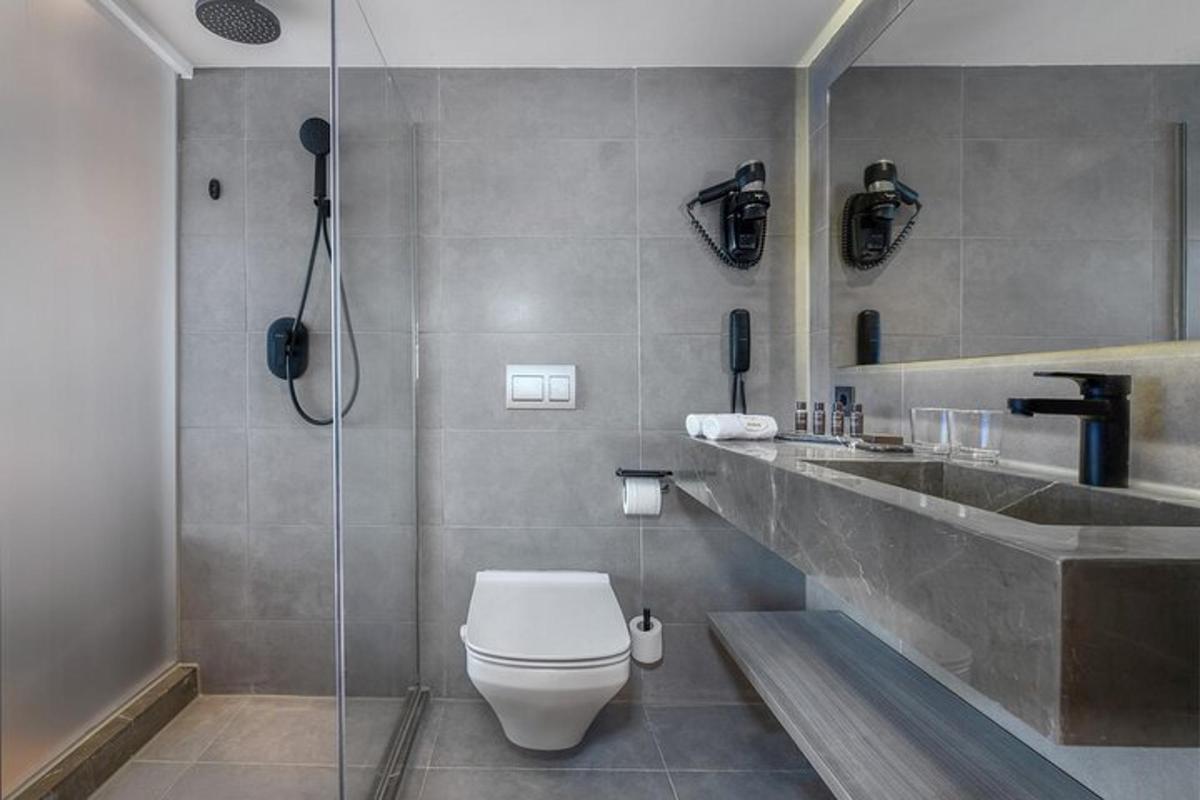 un bagno con doccia, WC e lavandino