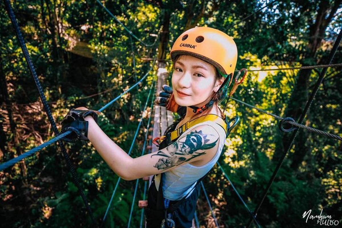 una ragazza con un casco arancione che si arrampica su una pista a ostacoli