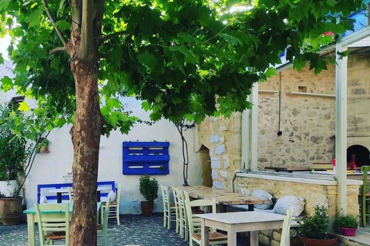 μια βεράντα με τραπέζια και καρέκλες και ένα δέντρο
