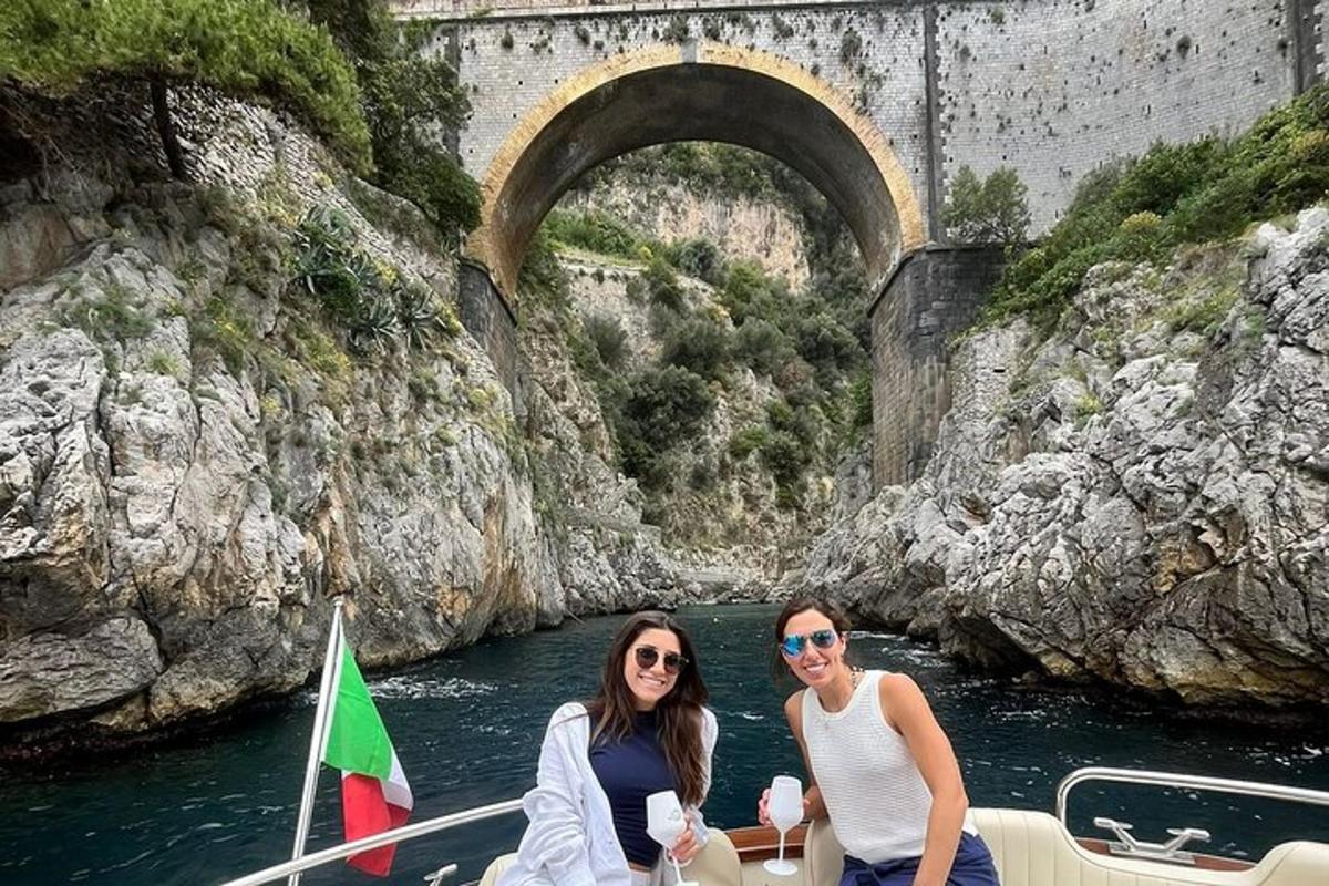 Dos mujeres en un barco en el agua debajo de un puente