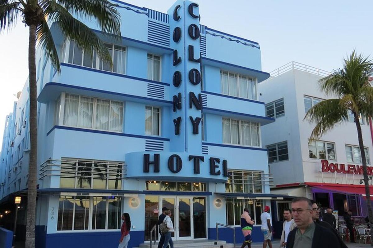 a blue hotel with people walking in front of it