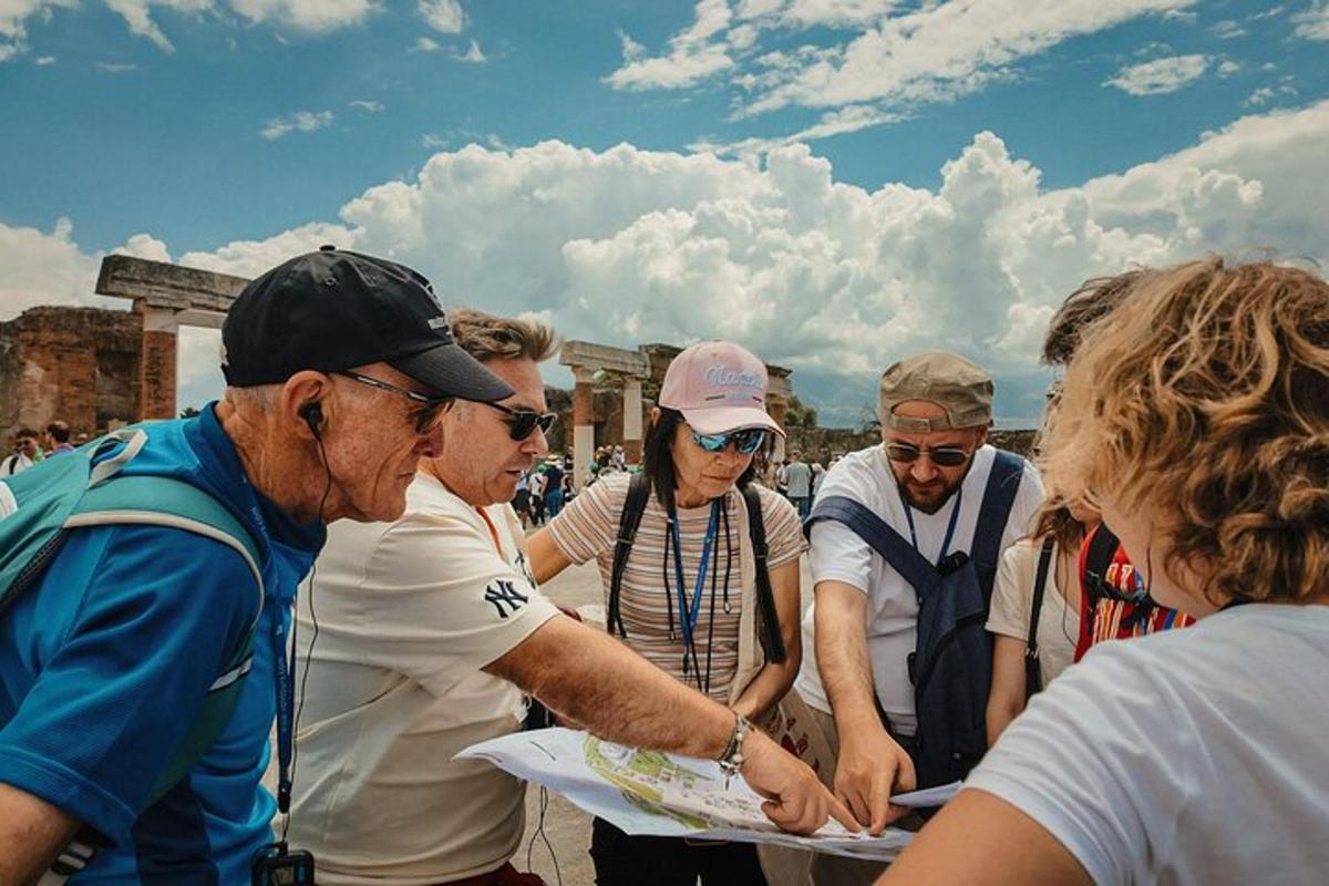 skupina lidí stojící kolem muže držícího papír