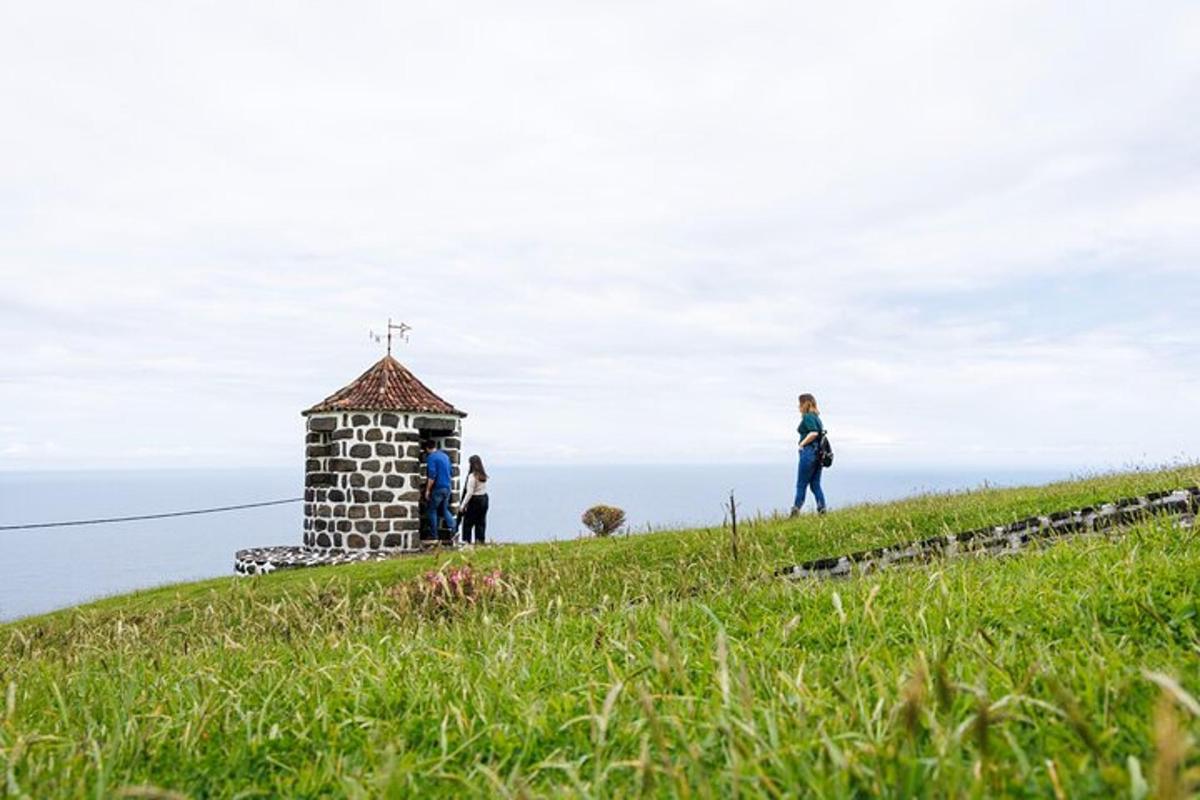 sekumpulan orang berdiri di sebelah sebuah gereja kecil di atas bukit