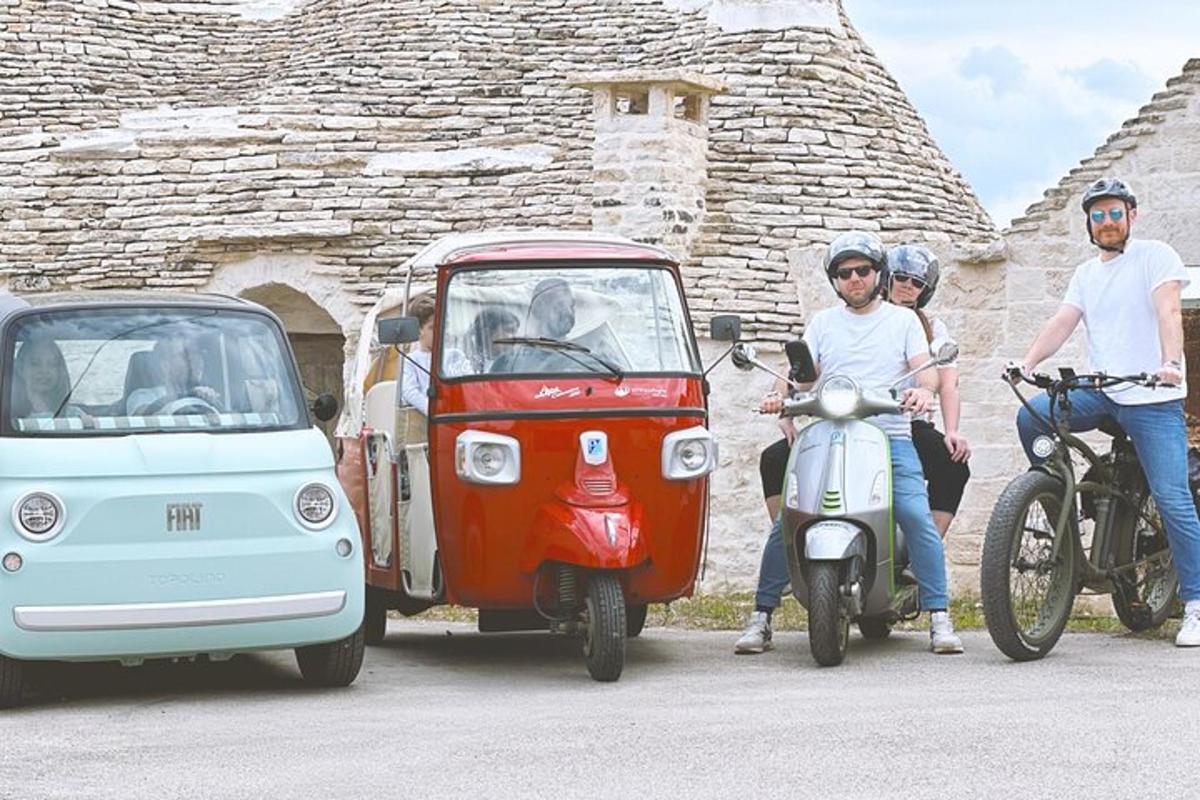 Un grupo de personas que viajan en motocicletas y un automóvil pequeño.