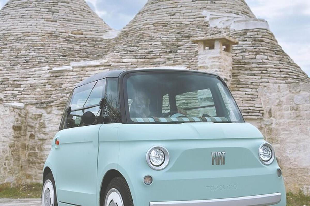 Un coche azul aparcado delante de un edificio de piedra.