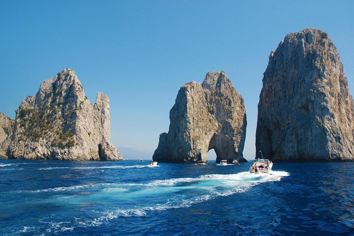 una barca in acqua vicino ad alcune grandi rocce